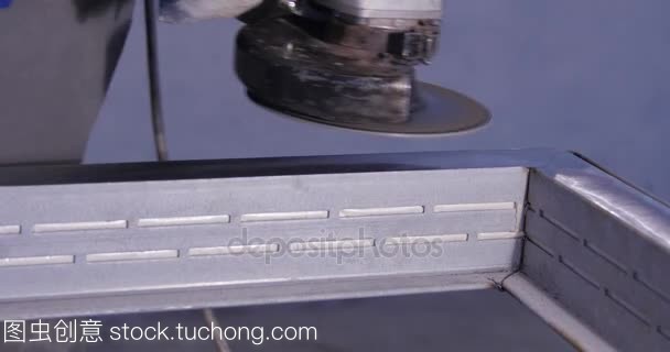 金屬鋸盤磨床車間的工匠。用火花磨削金屬。電動(dòng)砂輪廠低速快門的鋼結(jié)構(gòu)。金屬磨削與橙色飛行
